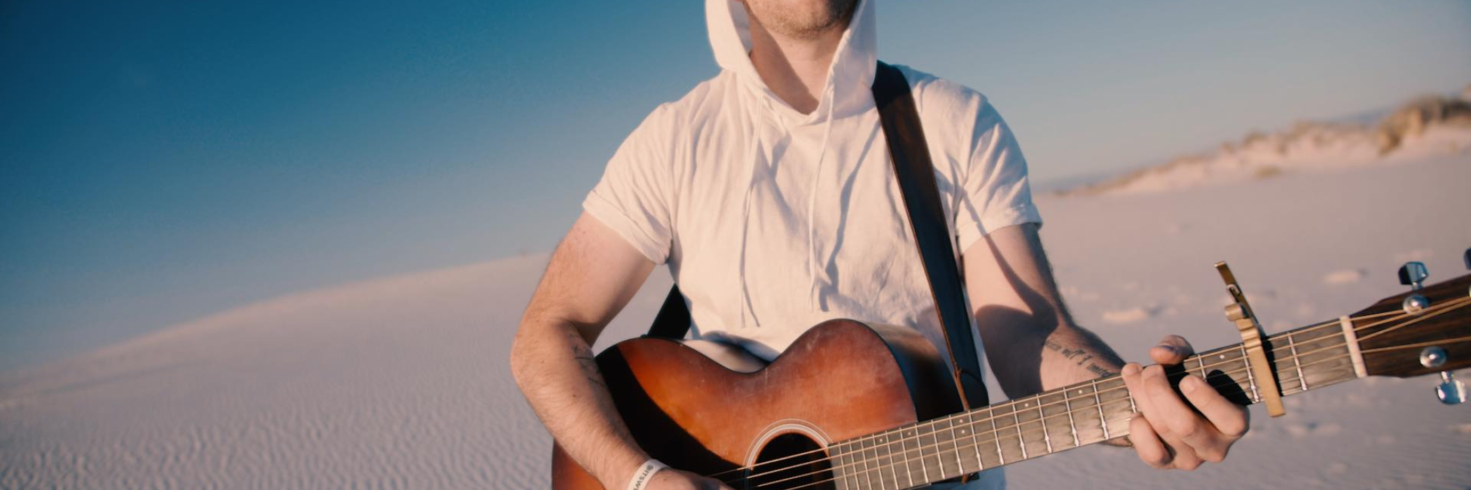 Ian Biggs on the guitar on the beach