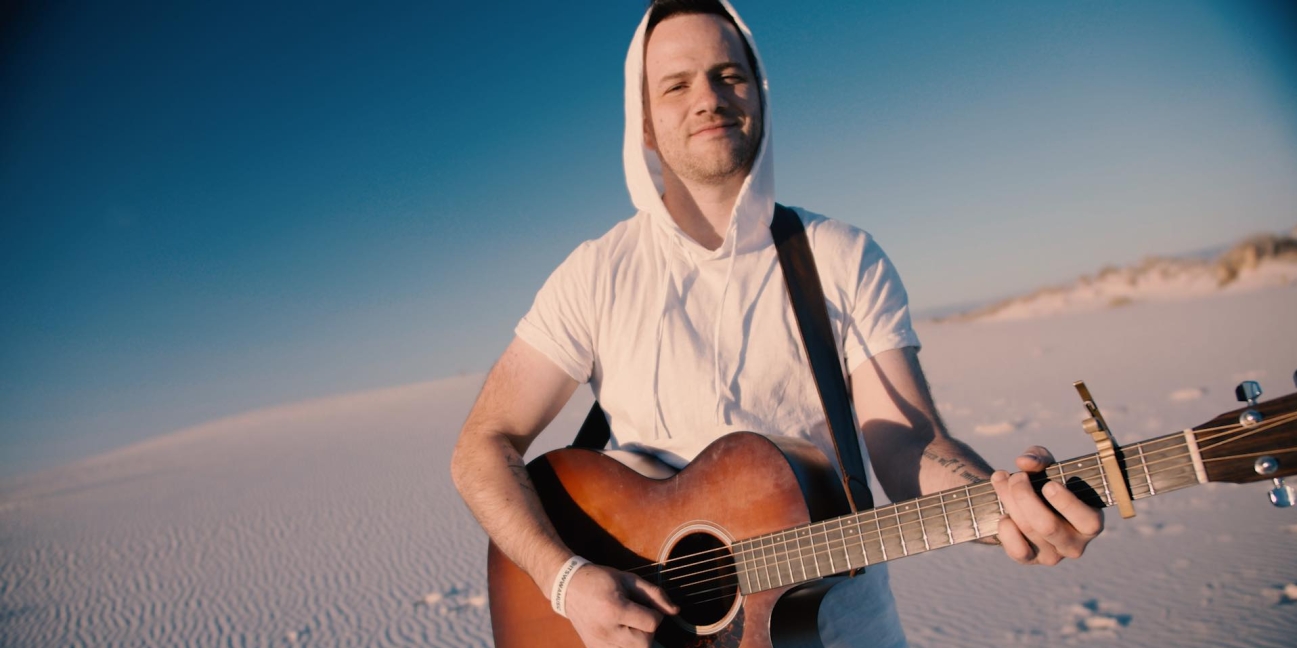 Ian Biggs on the guitar on the beach