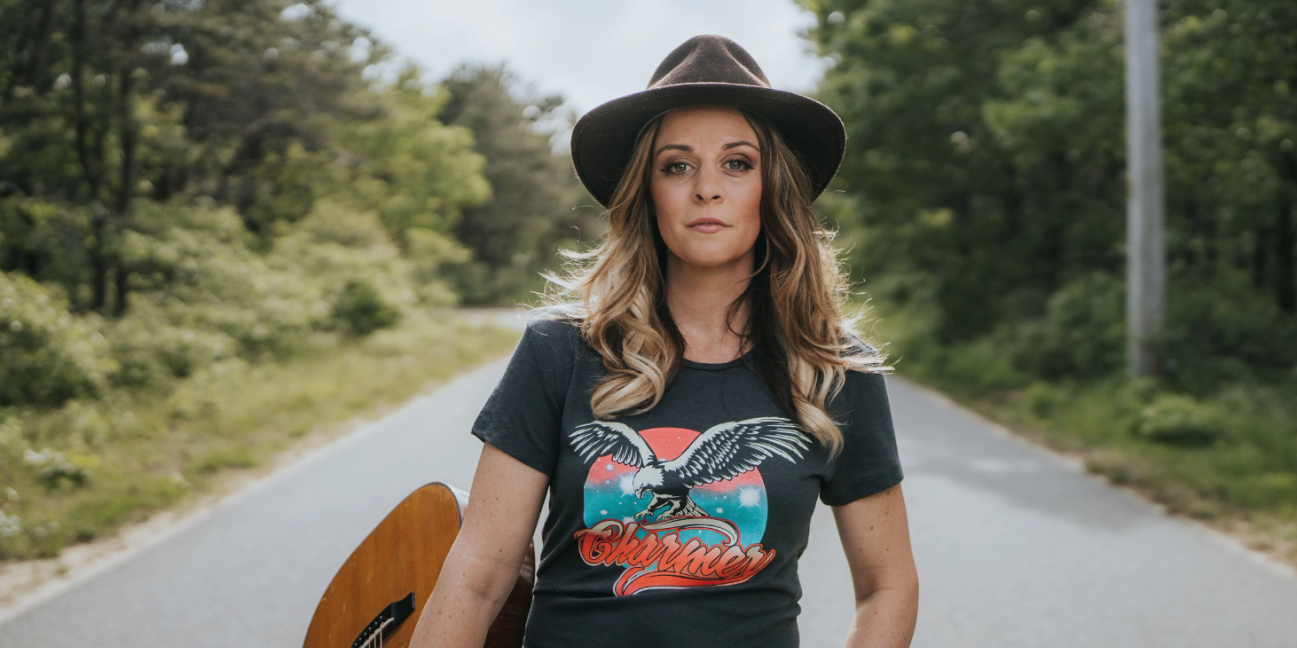 Monica Rizzio guitar in tow on a road